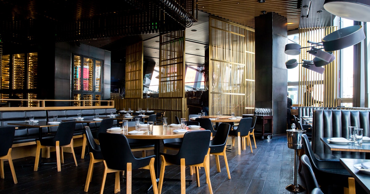 Restaurant staff during busy service with AI assistant handling phone enquiries